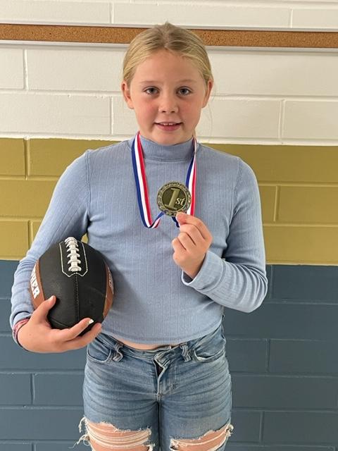 girl wearing a medal and holding a football