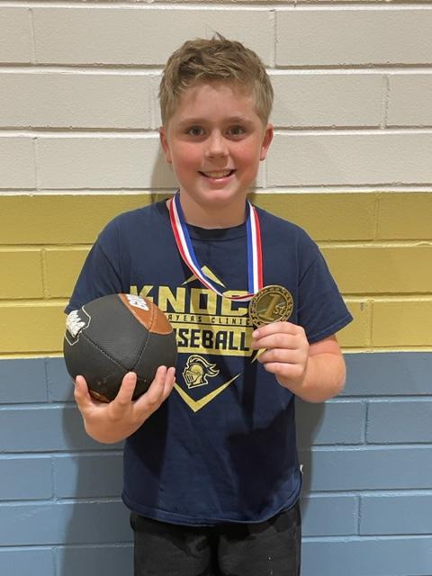 boy wearing a medal and holding a football