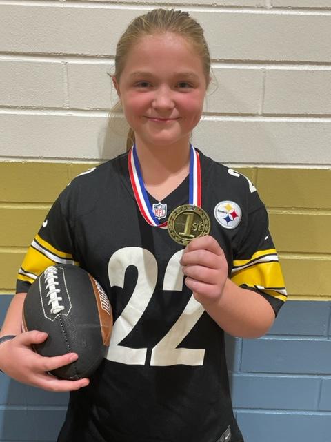 girl wearing a medal and holding a football