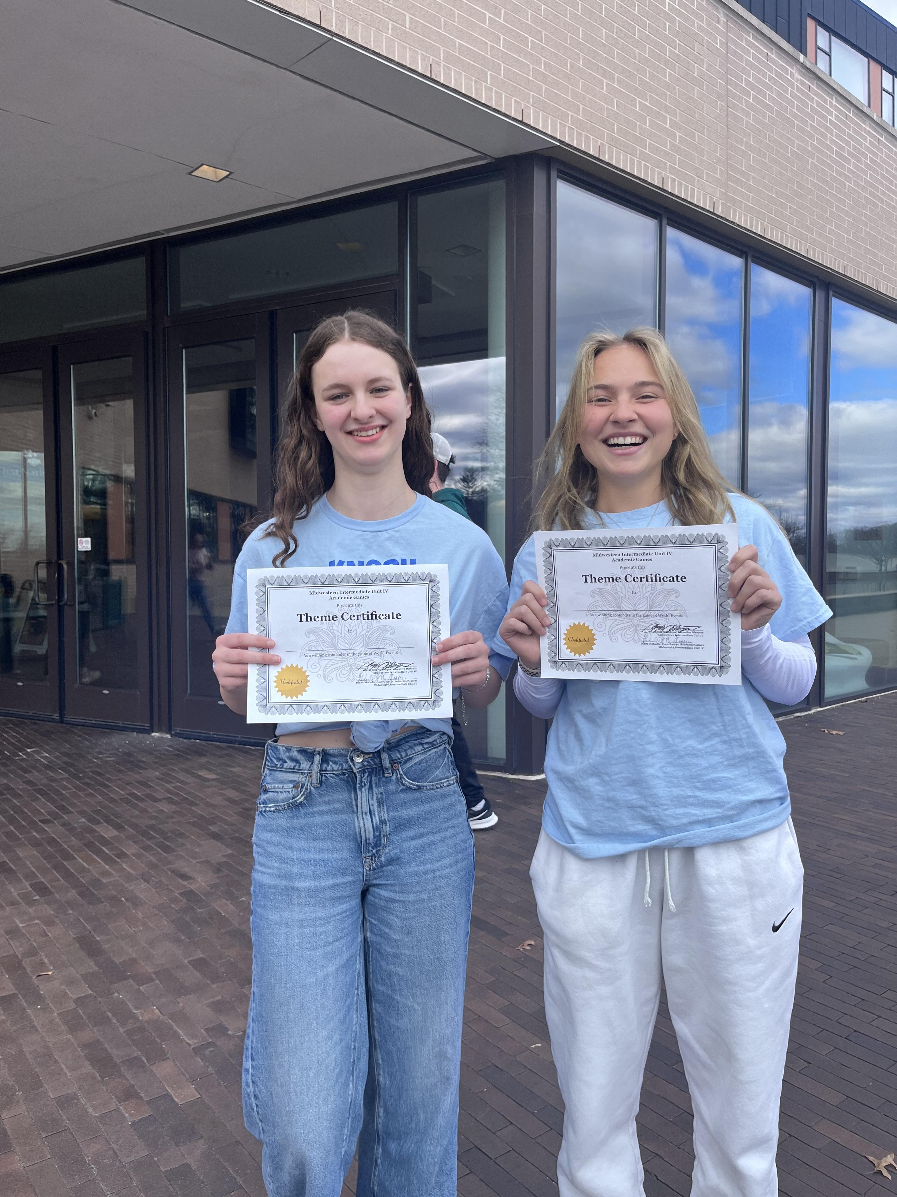 2 students holding certificates